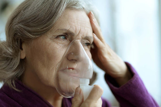 Femeie in varsta folosind masca de aerosoli