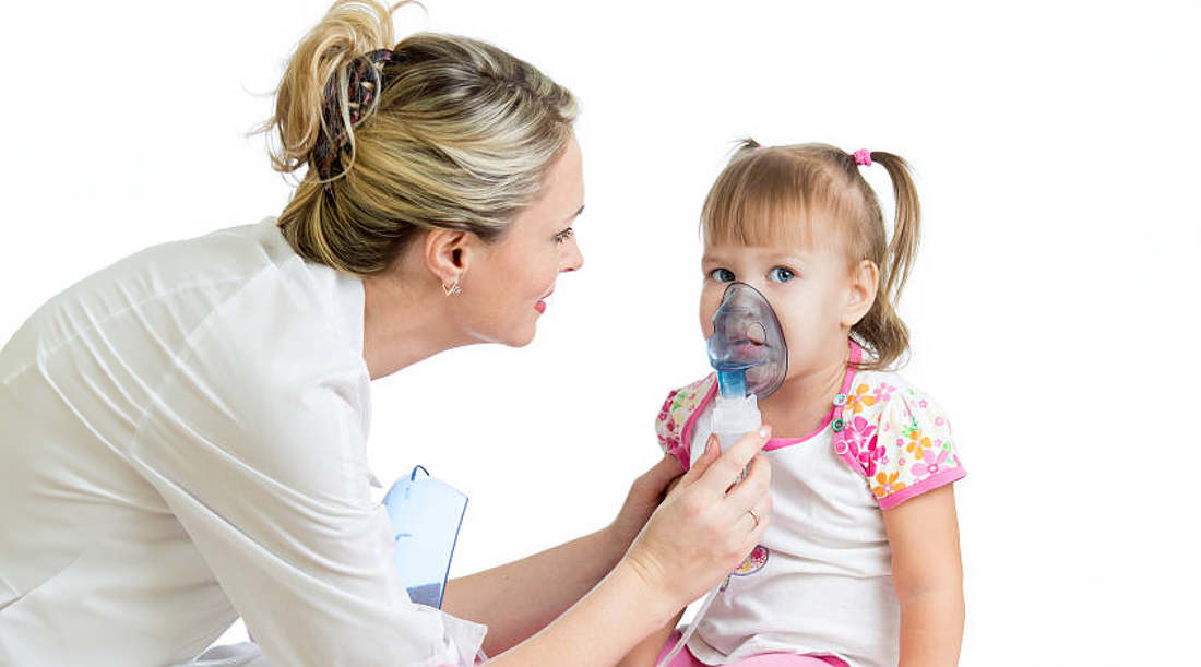 Cadru medical pune o masca de aerosoli unei fetite